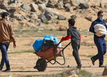 نازحون سوريون يحصلون على الخبز ومواد غذائية